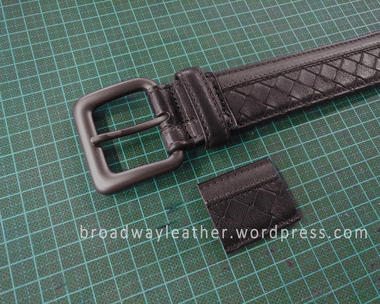 A shortened Bottega Veneta belt, with a segment of the cut off leather strap next to the belt