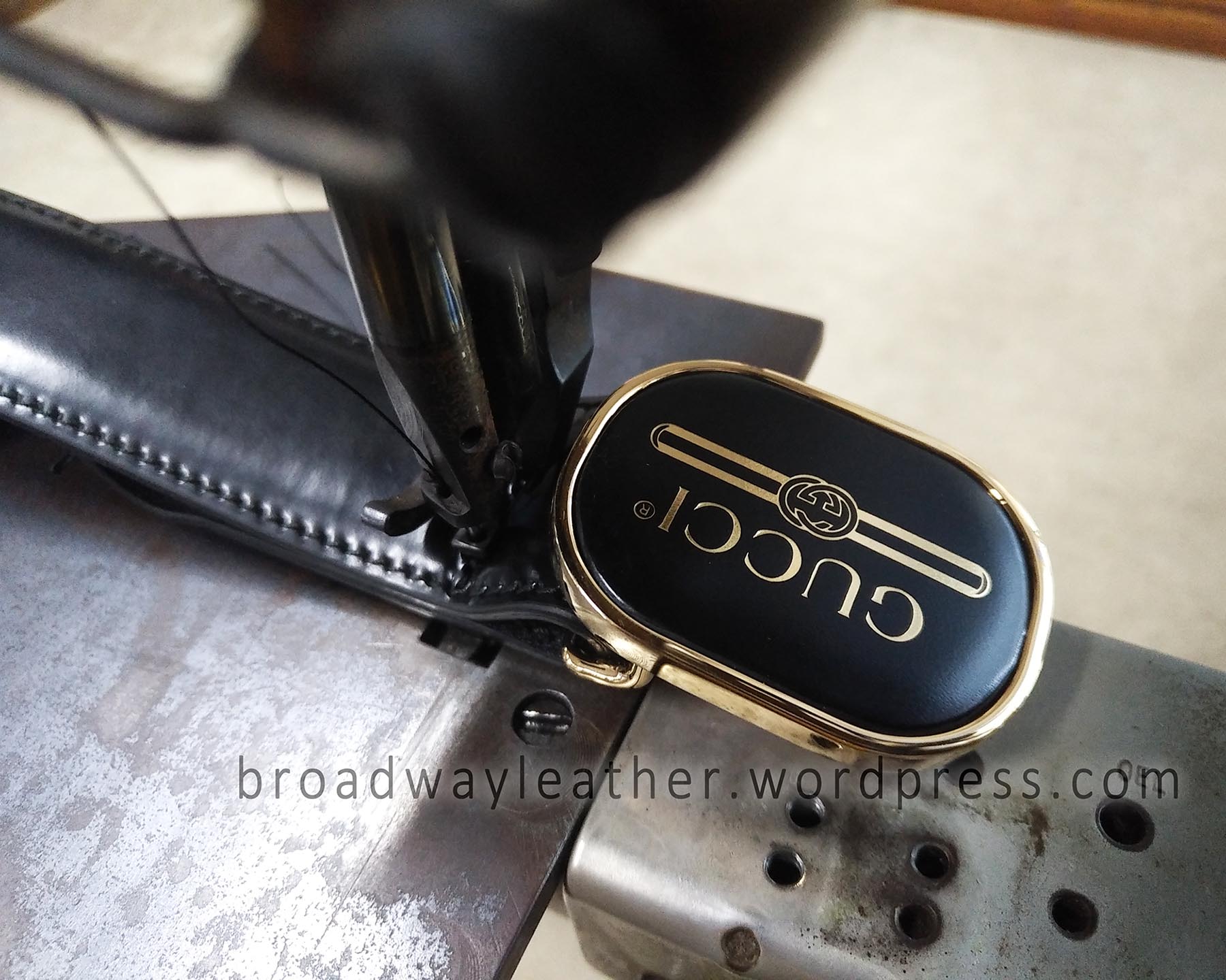 Close-up of a Gucci belt at the sewing machine being resewn after shortening