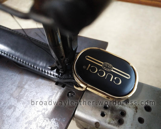 Close-up of a Gucci belt at the sewing machine being resewn after shortening